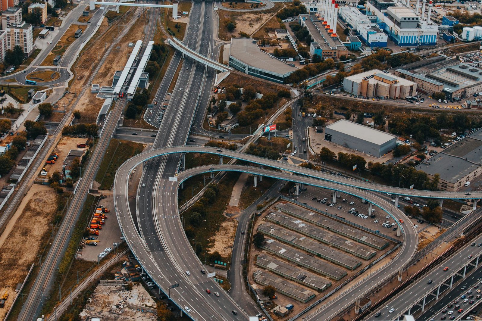 Aerial view of a complex multi-level highway interchange in a city, with overlapping roadways and traffic lanes.