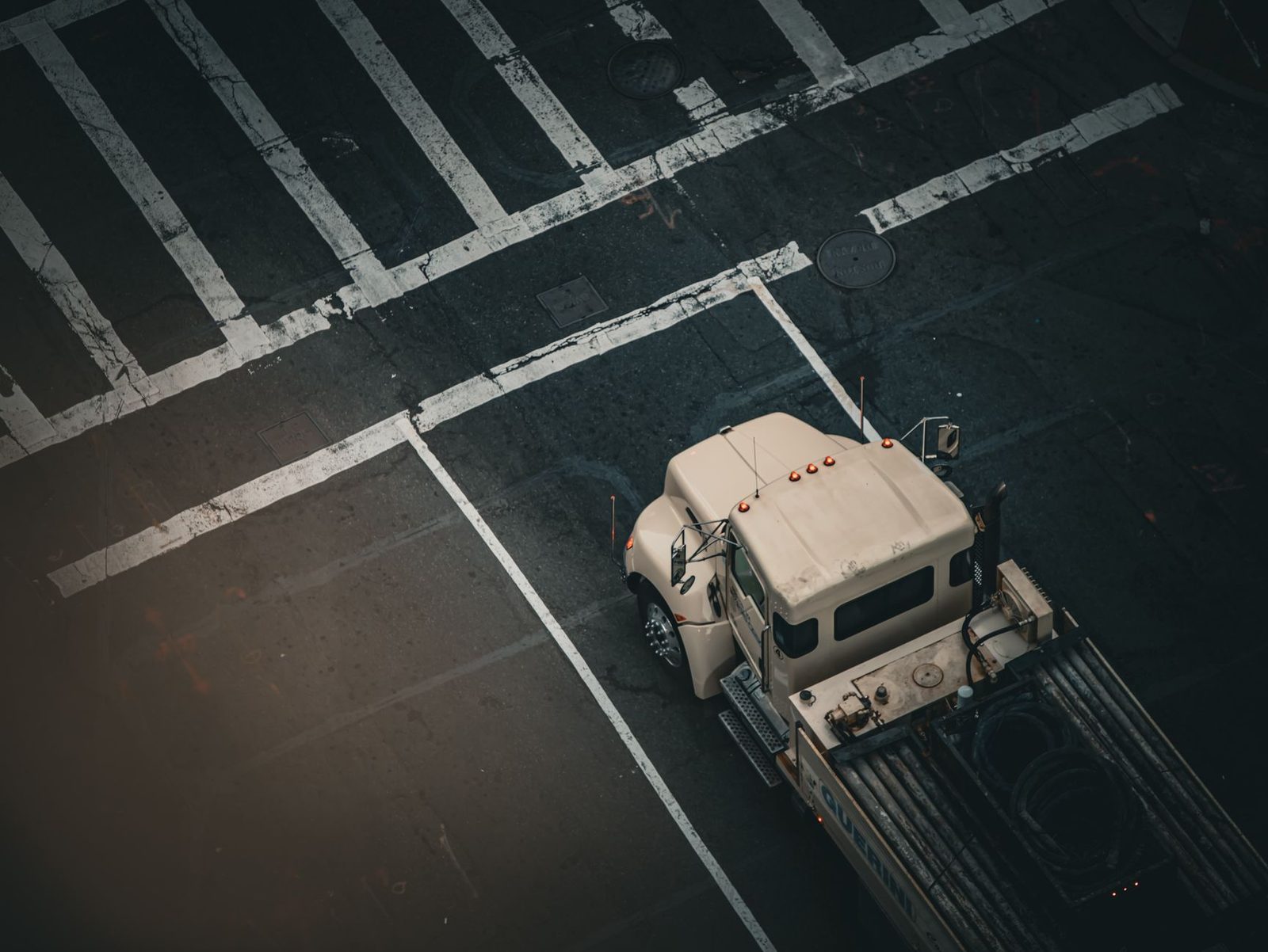 Aerial view of a truck stopped at a Boston city intersection, with painted street markings visible on the pavement.