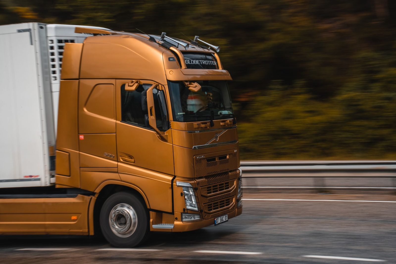 An orange truck speeding down a highway.