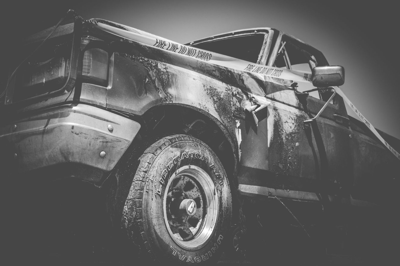 Damaged truck at accident scene with police tape.