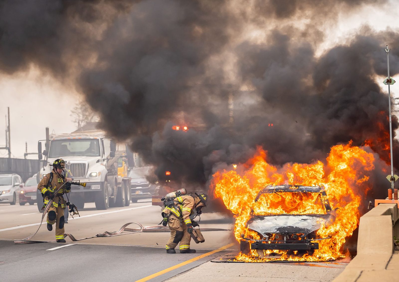 Firefighters extinguishing a burning car on a Virginia highway.