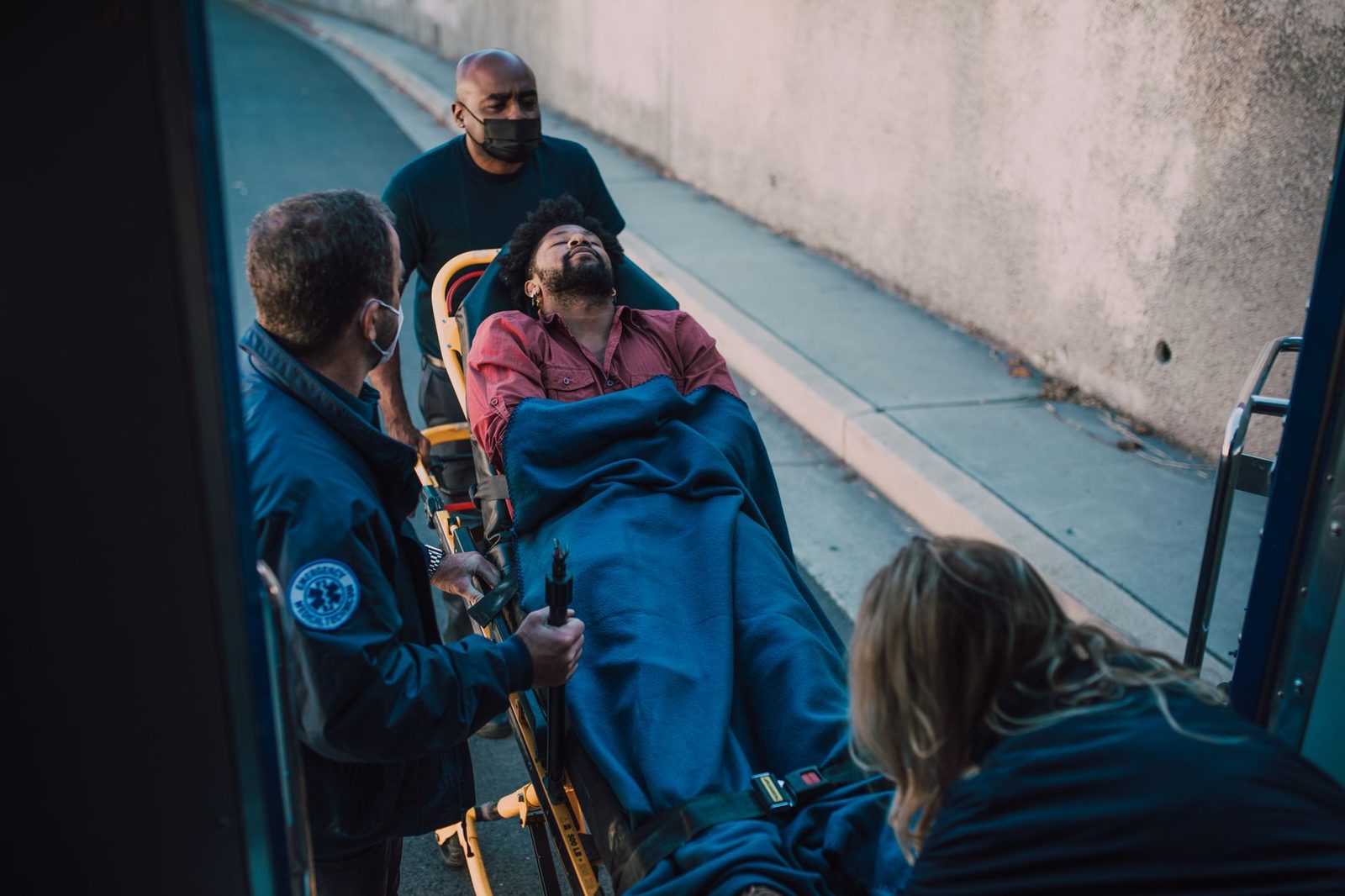 Paramedics transport an injured patient on a stretcher during emergency response.