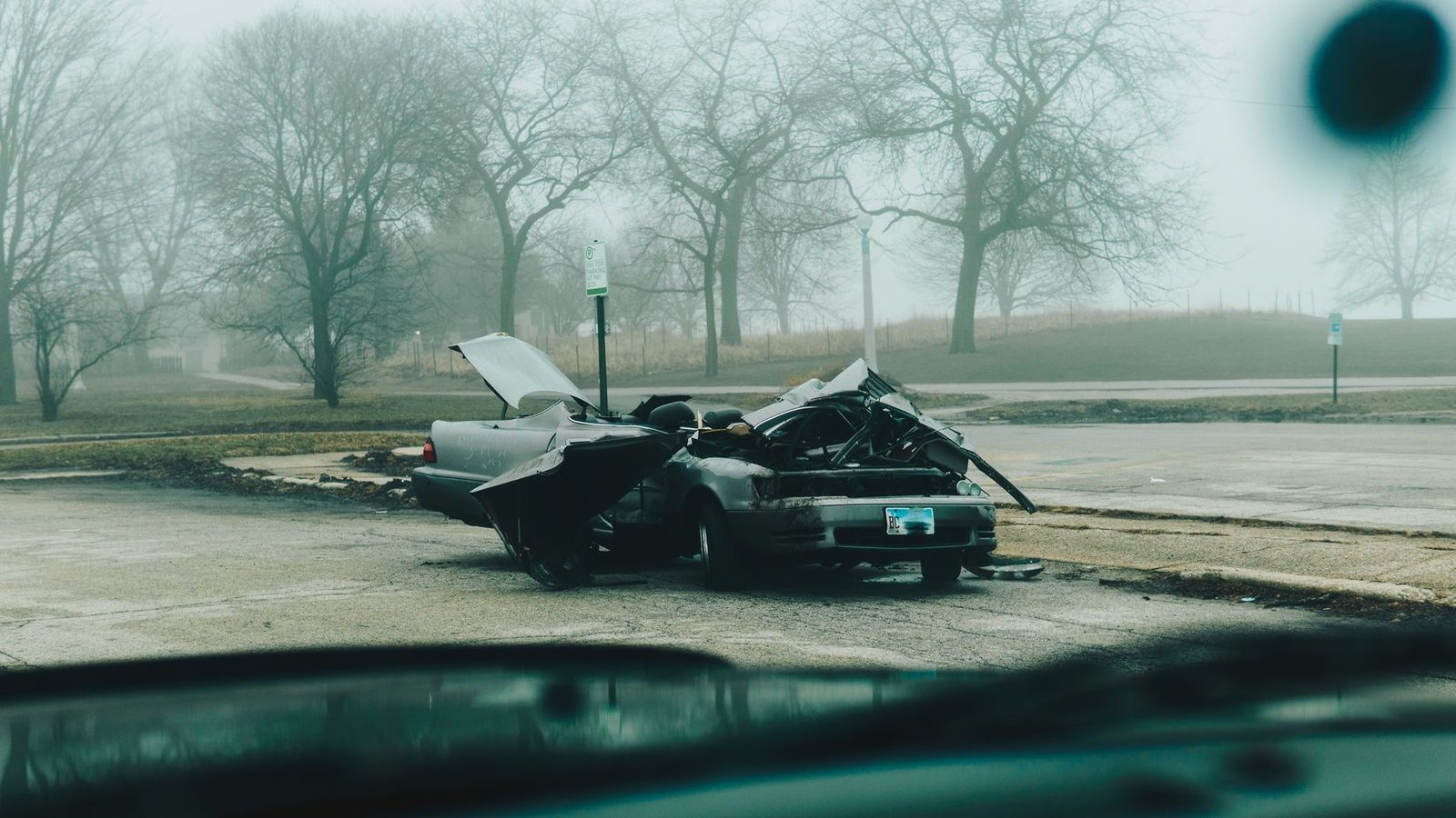 Severely damaged car on a foggy street after collision.