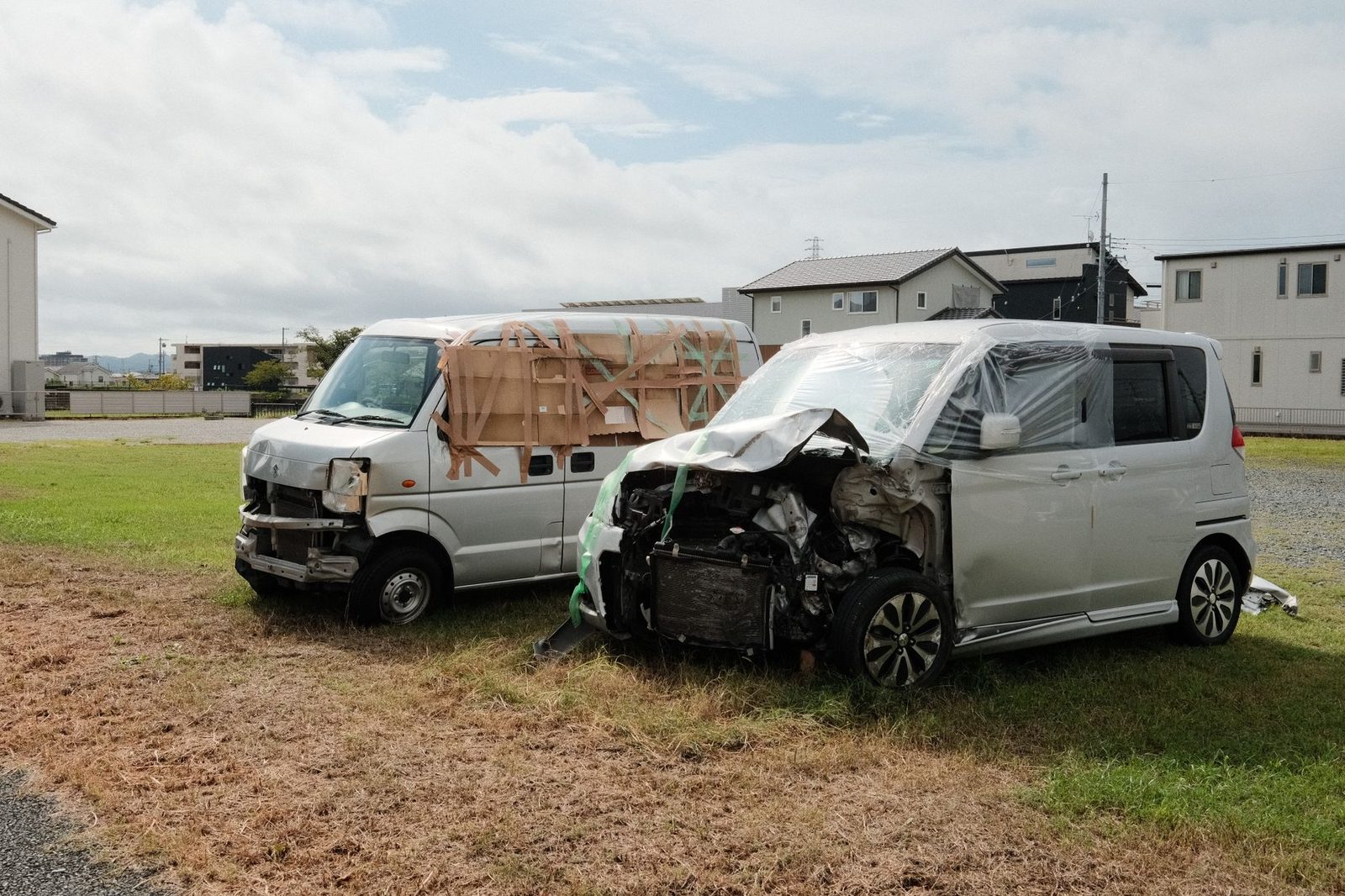 Two damaged vans after a collision on grass.