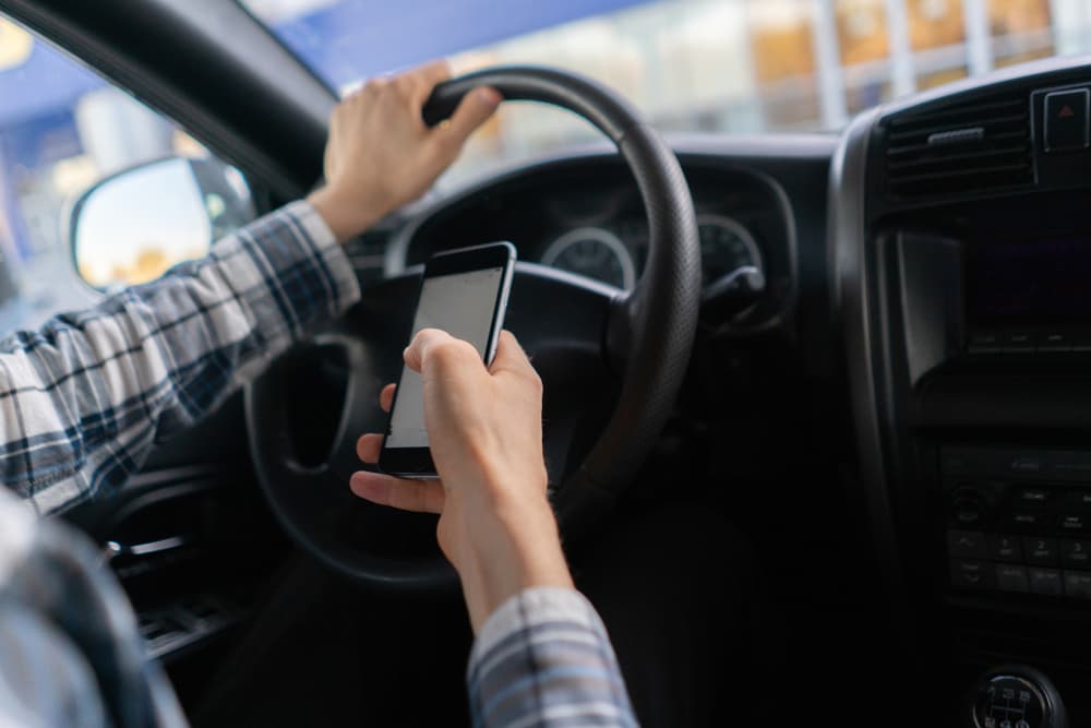 A Man Using Smart phone while driving