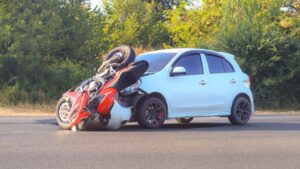 Motorcycle accidents with a car, causing both damages.